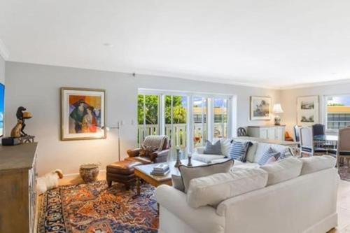 a living room with a white couch and a table at Two Bedroom Bayfront Condo with Water Views in Naples