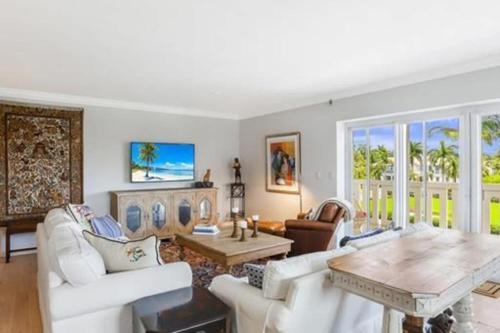 a living room with white furniture and a table at Two Bedroom Bayfront Condo with Water Views in Naples