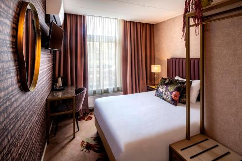a hotel room with a bed and a window at Hotel Wesseling in Dwingeloo