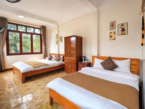 a bedroom with two beds and a window at Nấm Homestay in Sapa