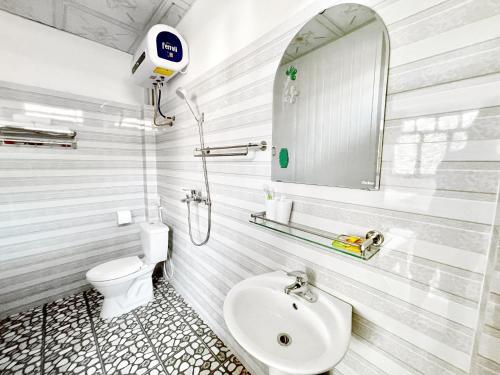 a bathroom with a sink and a toilet and a mirror at Nấm Homestay in Sapa