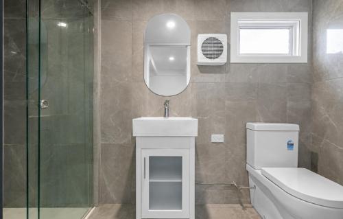 a bathroom with a toilet and a sink and a mirror at Tranquillity by the sea in Killarney