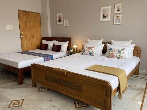 two beds in a room with two bedsitures at Nilayam guest house in Patna