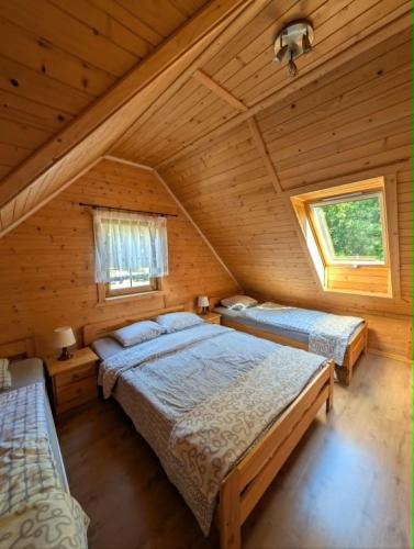 a bedroom with two beds in a log cabin at Domki AGA in Mrzeżyno