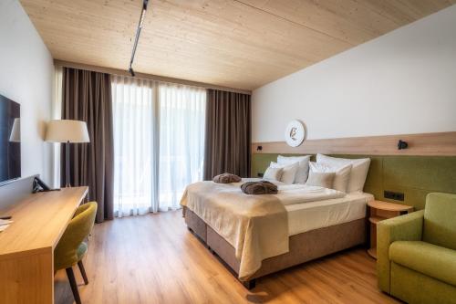 a hotel room with a bed and a desk at NaturHotel Snovik in Kamnik