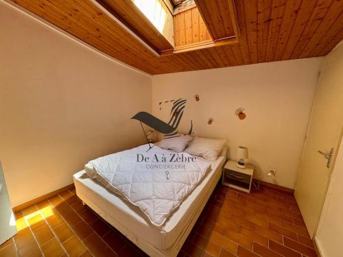 a bedroom with a bed with a lamp on it at L'Océane - Maison au calme avec terrasse, centre de Bourg in Le Port-des-Barques