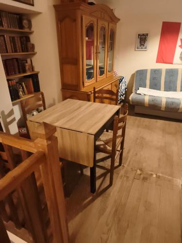 a dining room with a wooden table and chairs at Chambre pèlerinage in Saint-Hilaire-la-Palud