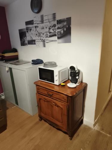 a microwave sitting on top of a wooden table at Chambre pèlerinage in Saint-Hilaire-la-Palud