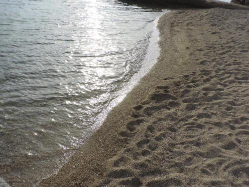 a beach with footprints in the sand next to the water at Villa Petra in Rab