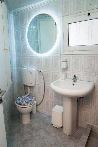 a bathroom with a toilet and a sink and a mirror at Joanna's House in Koumaradaíoi
