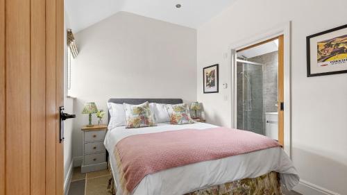 a bedroom with a bed with a pink blanket at Applewood in Harome