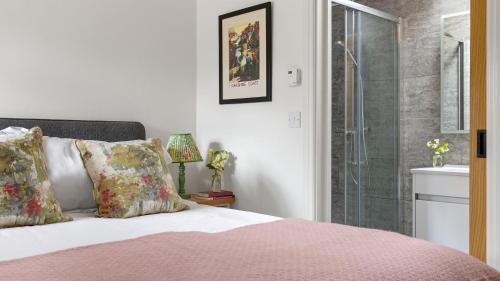 a bedroom with a bed and a glass shower at Applewood in Harome