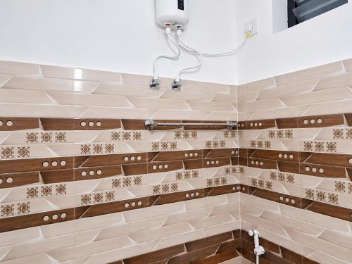 a bathroom with brown and white tiles at Hotel Sabareesh Kanyakumari in Golden Rock