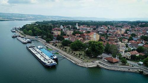 a large boat is docked at a dock on a river at Apartman Dejanović 1 in Veliko Gradište