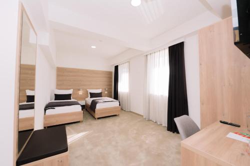 a hotel room with two beds and a desk at Sobe B&M Livno in Livno