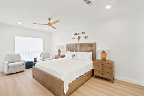 a white bedroom with a bed and a chair at Riviera Dunes 501 in Perdido Key