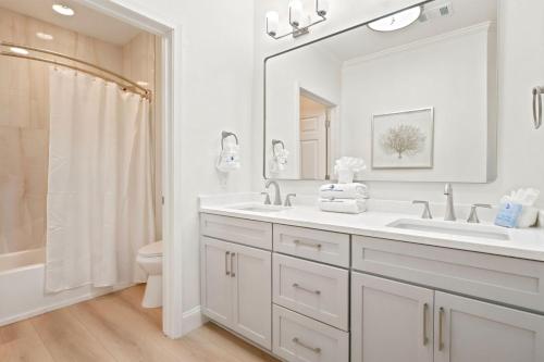 a white bathroom with a sink and a mirror at Riviera Dunes 501 in Perdido Key