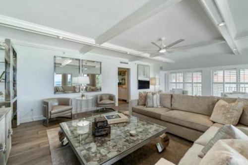 a living room with a couch and a table at Three Bedroom Gulffront Condo with Sunset Views in Naples