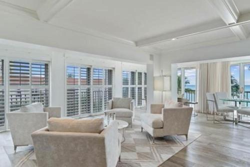 a living room with couches and chairs and a table at Three Bedroom Gulffront Condo with Sunset Views in Naples