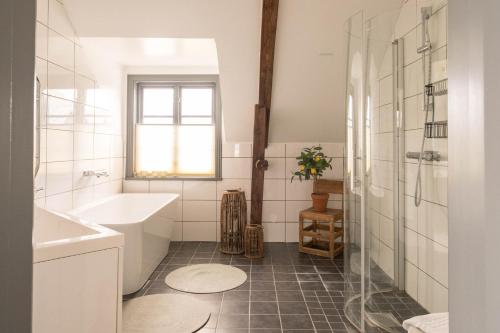 a bathroom with a sink and a tub and a shower at Gumbalde Resort in Stånga