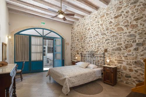 a bedroom with a bed and a stone wall at Villa Aposperitis in Panormos Rethymno