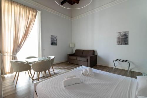 a white room with a bed and a table and a couch at Villa Cua in Ercolano