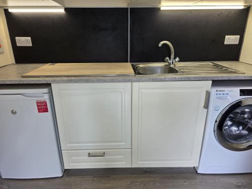 a kitchen with a sink and a washing machine at Cosy Condo near City & Airport in Dublin