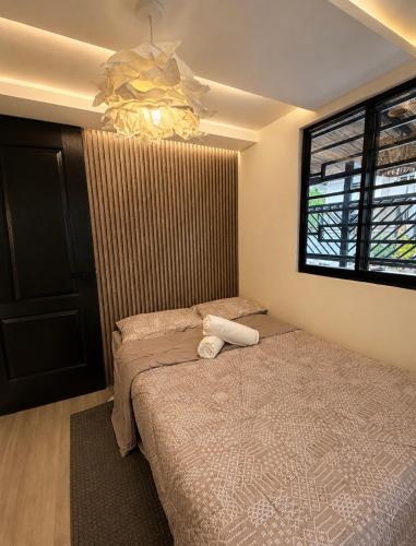 a bedroom with a bed and a chandelier at Casa Aelliah in General Santos