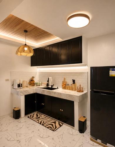 a kitchen with black cabinets and a counter top at Casa Aelliah in General Santos