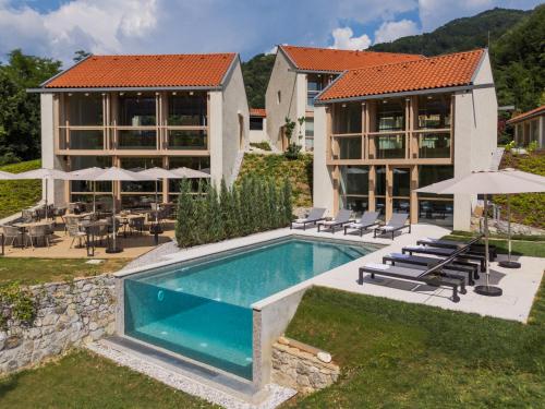 a house with a swimming pool next to a building at Zen Emerald Resort & Spa, Soča river in Most na Soči