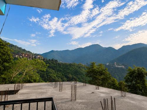 a large parking lot with mountains in the background at Anamika Forest View 1RK Near Kempty Falls Mussoorie in Mussoorie