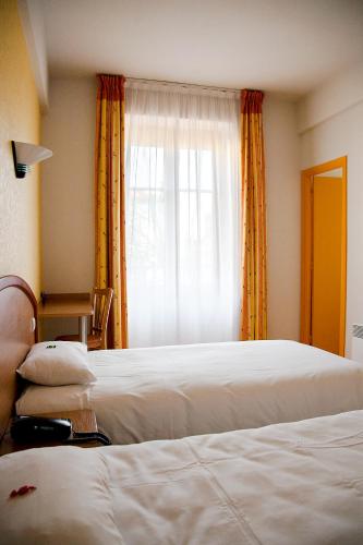 Кровать или кровати в номере Logis Hôtel du Commerce