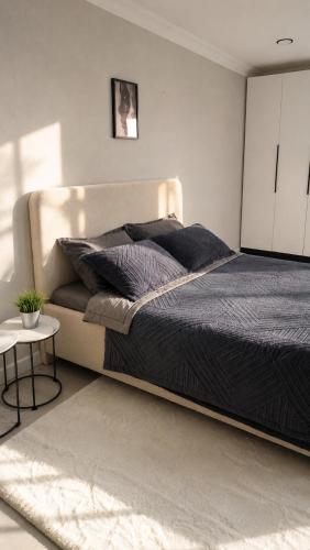 a bedroom with a large bed with black sheets at Sunset Apartment Aktau Квартира в центре у моря in Aktau