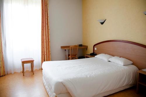 Кровать или кровати в номере Logis Hôtel du Commerce