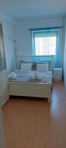 a large bed in a room with a window at Katica Apartman in Kehidakustány
