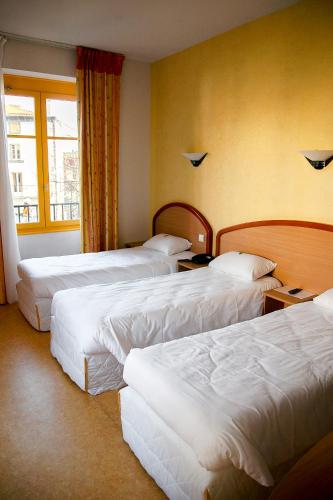 Кровать или кровати в номере Logis Hôtel du Commerce