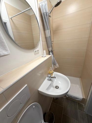 a small bathroom with a sink and a mirror at Hotel Wandsbek Hamburg in Hamburg