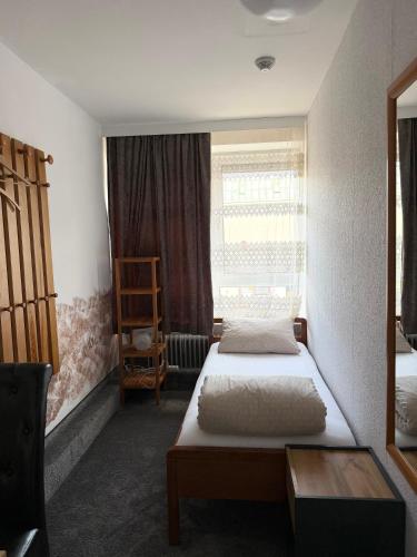 two beds in a small room with a window at Hotel Wandsbek Hamburg in Hamburg