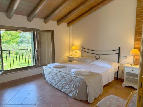 a bedroom with a large bed and a window at Residence Borgo Mondragon in Lazise