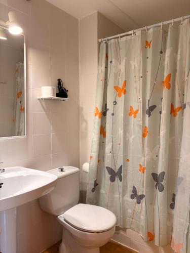 a bathroom with a toilet and a shower curtain with butterflies at Agradable y rústico, perfecto para parejas - Cuc 7 in Pla de l'Ermita