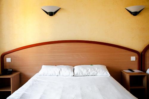 Кровать или кровати в номере Logis Hôtel du Commerce