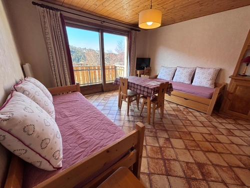 a bedroom with a table and a bed and a dining room at Studio Crêt du Midi, Chez Francine in Notre-Dame-de-Bellecombe