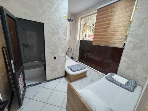 a bathroom with a shower and a toilet and a tub at Shinam hostel 777 in Chilanzar