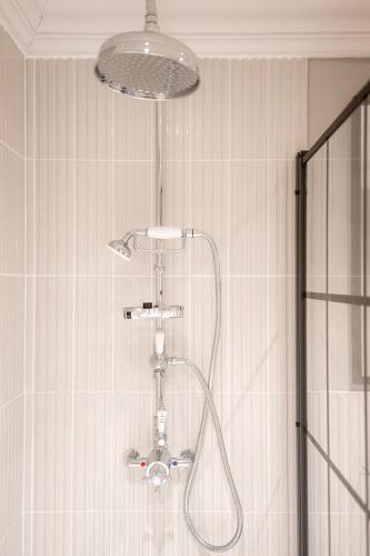 a shower with a shower head in a bathroom at Angel @ KingSt in Knutsford