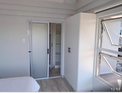 a white room with a bed and a window at Beautiful Lagoon House in Blythedale