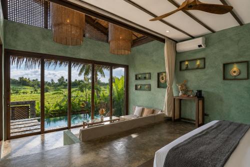a bedroom with a bed and a large window at Tanaw Villas in General Luna