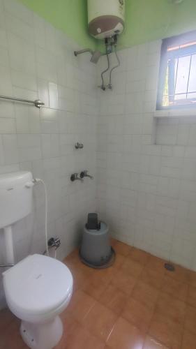 a bathroom with a white toilet and a sink at yercaud Happy valley cottage in Yercaud