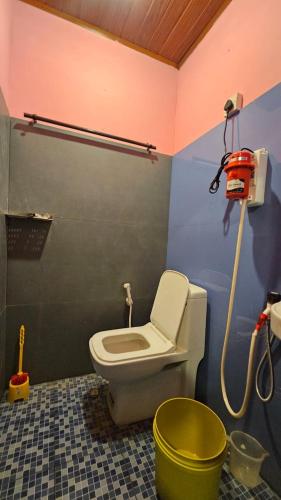a bathroom with a toilet in a room at WildCliff pool huts in Meppādi
