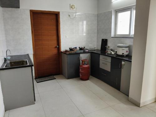 a kitchen with a red fire extinguisher in it at Green fields in Vijayawāda