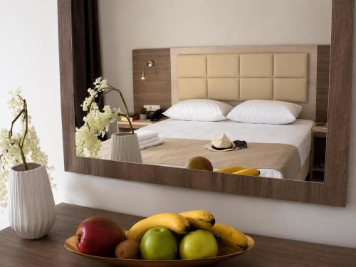 a bowl of fruit on a table in front of a bedroom at Perla Halkidiki in Kallithea Halkidikis